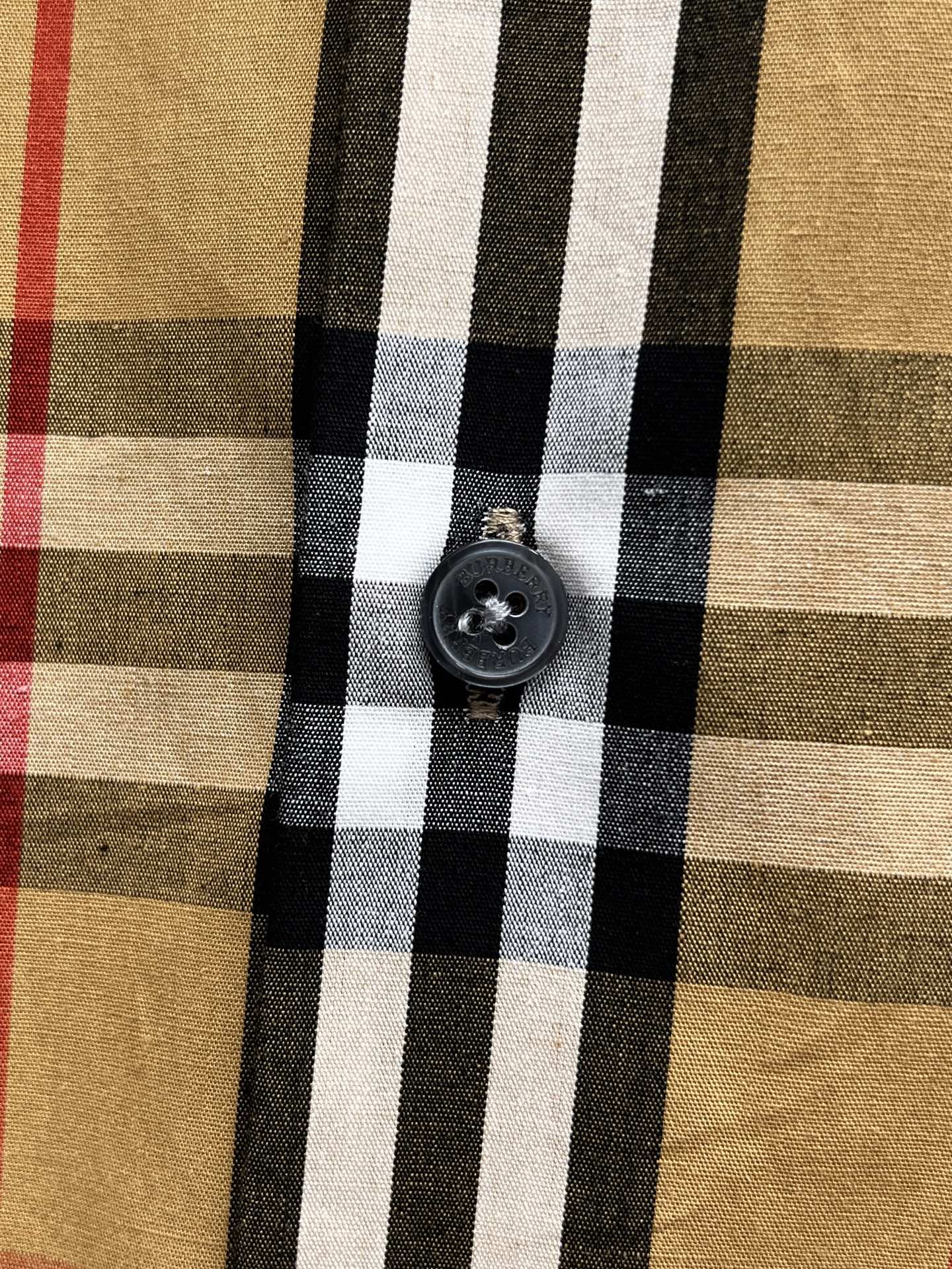 Plaid shirt close-up of round dark button on front placket