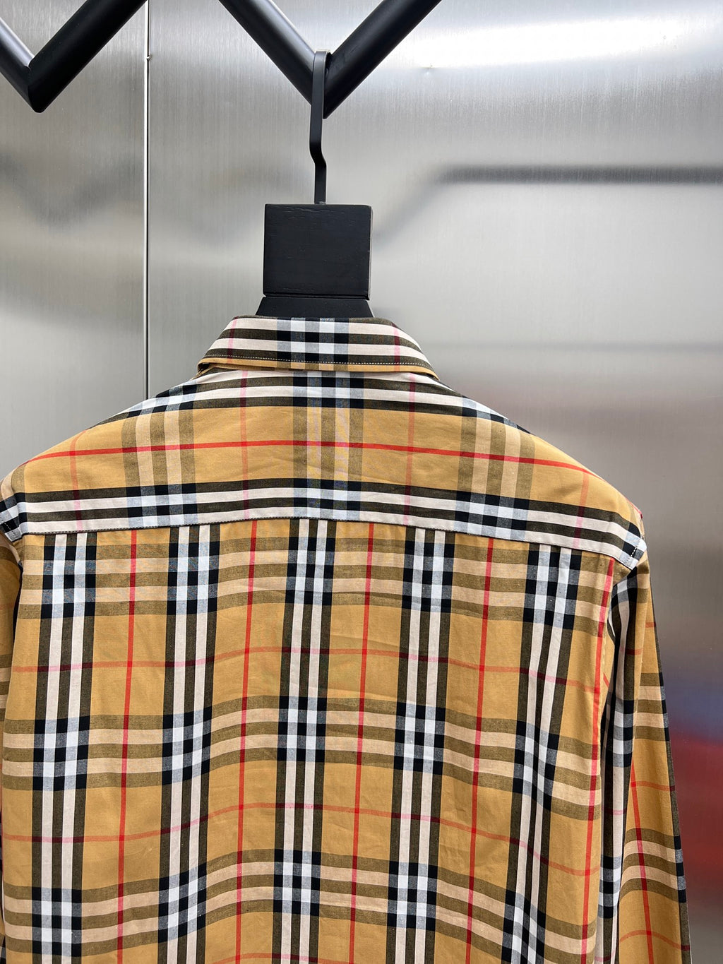 Burberry plaid long-sleeve shirt on hanger, back view, beige with black, white, and red plaid