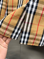 Plaid shirt cuff close-up with single button and stitched sleeve seam
