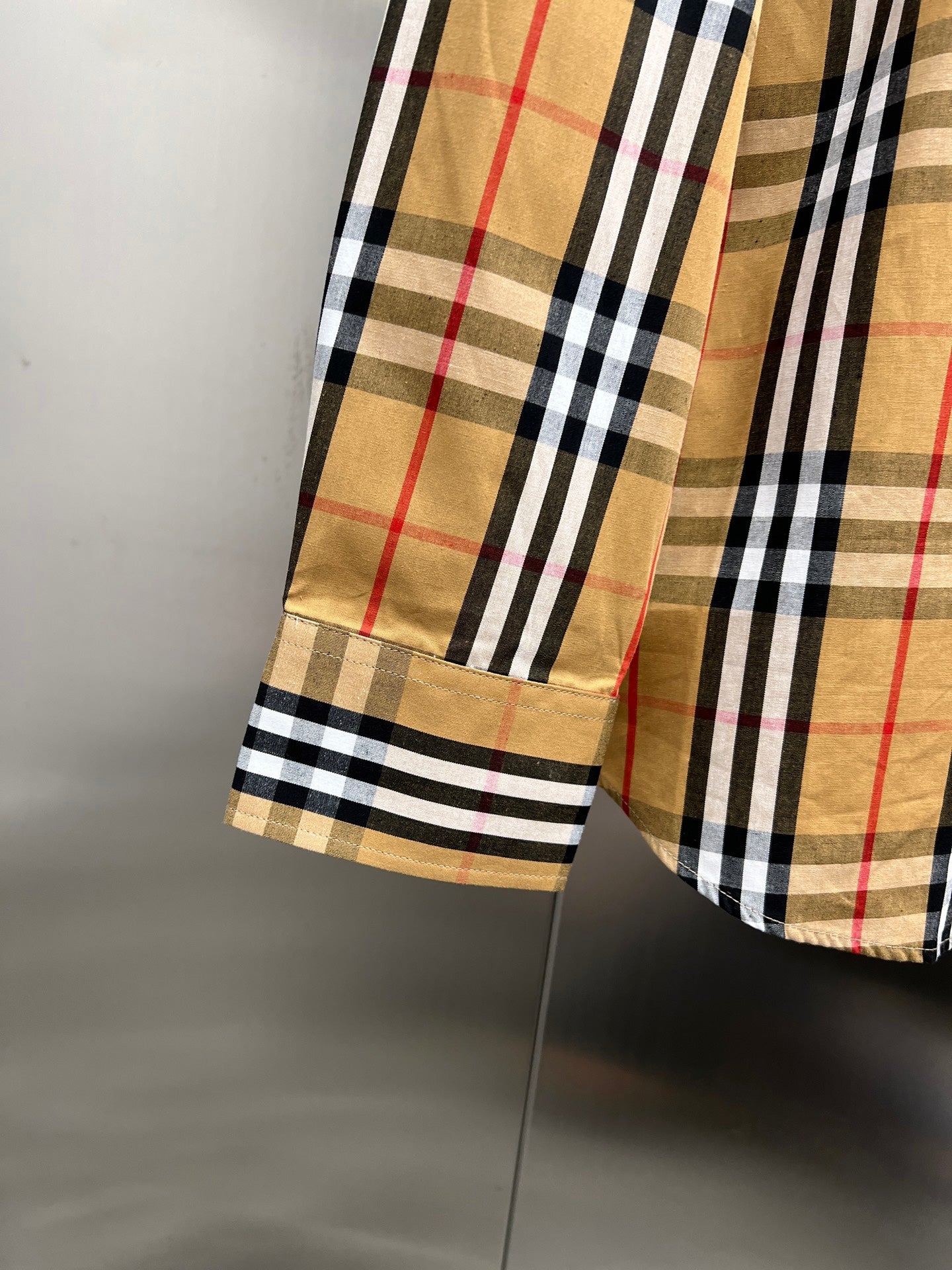 Plaid shirt sleeve hem with contrast facing and stitched cuff detail