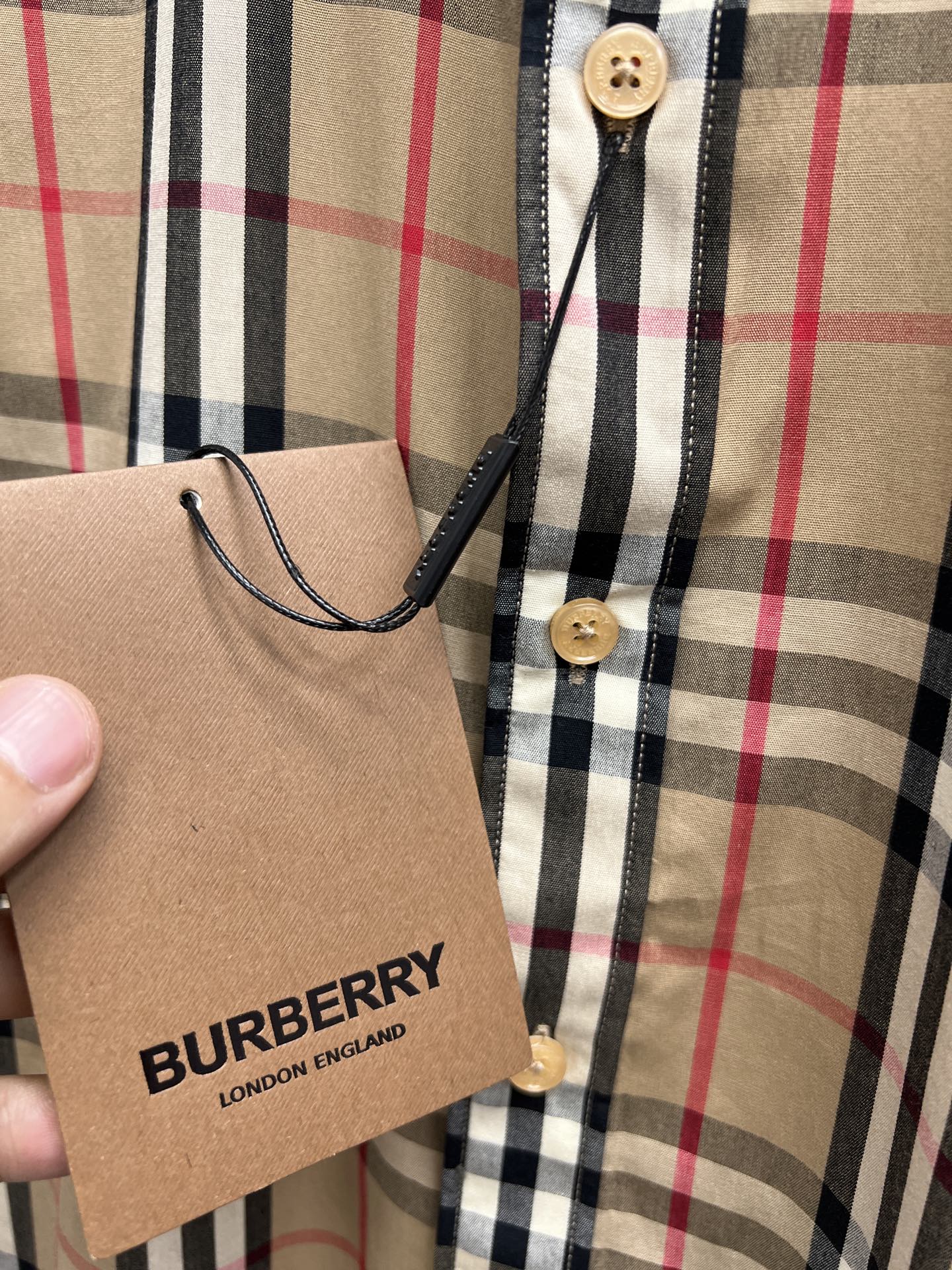 Shirt placket and neckline with buttons, plaid check in tan/black/red, Burberry tag