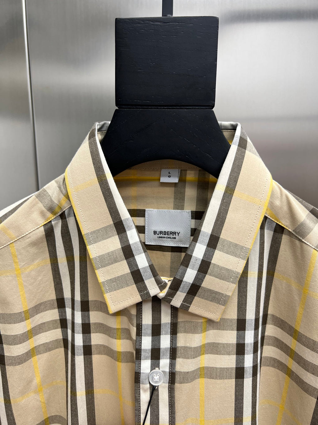 Plaid long-sleeve button-up shirt close-up of collar and placket, cream with black and yellow