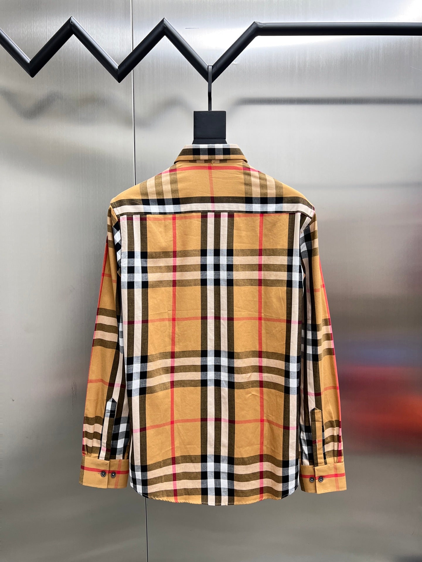 Long-sleeve plaid shirt on hanger, back view with yoke and buttons