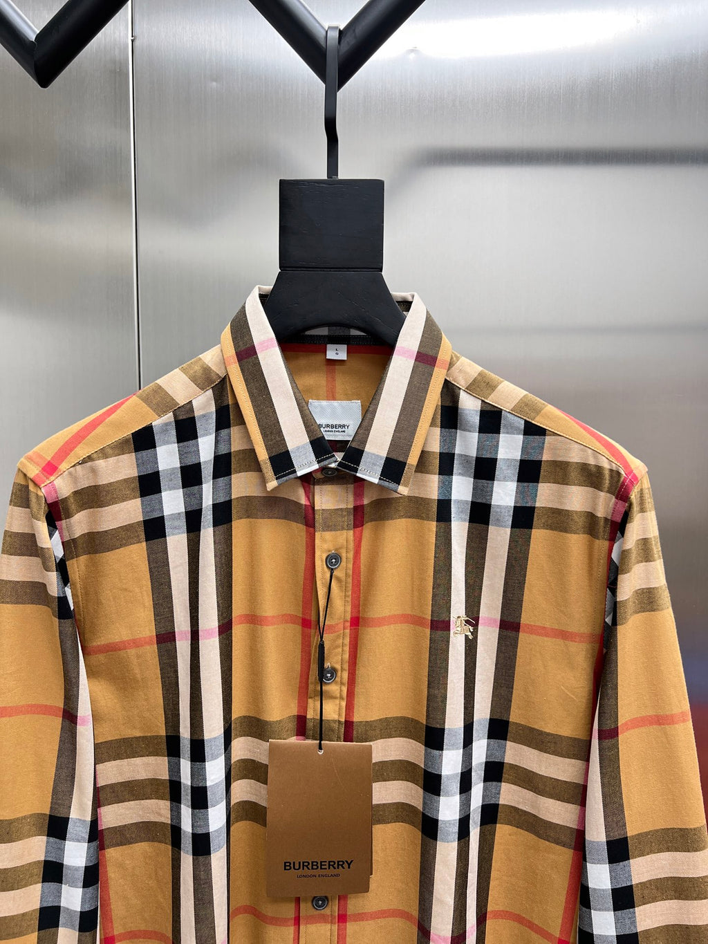 Long-sleeve plaid shirt close-up, button-front and embroidered chest detail