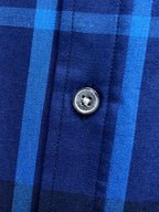 Round metal button on blue and white plaid shirt placket
