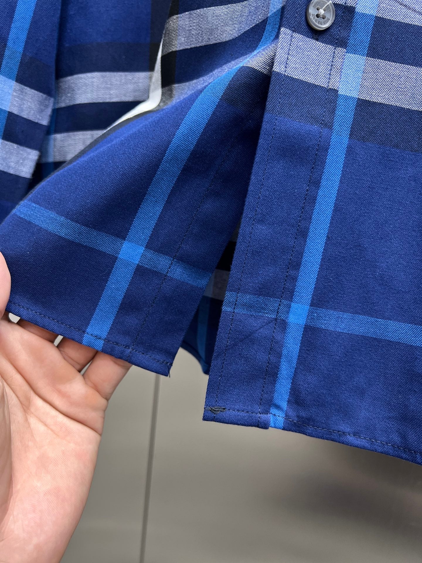 Long-sleeve button-up shirt in blue and white plaid, barrel cuffs, front placket