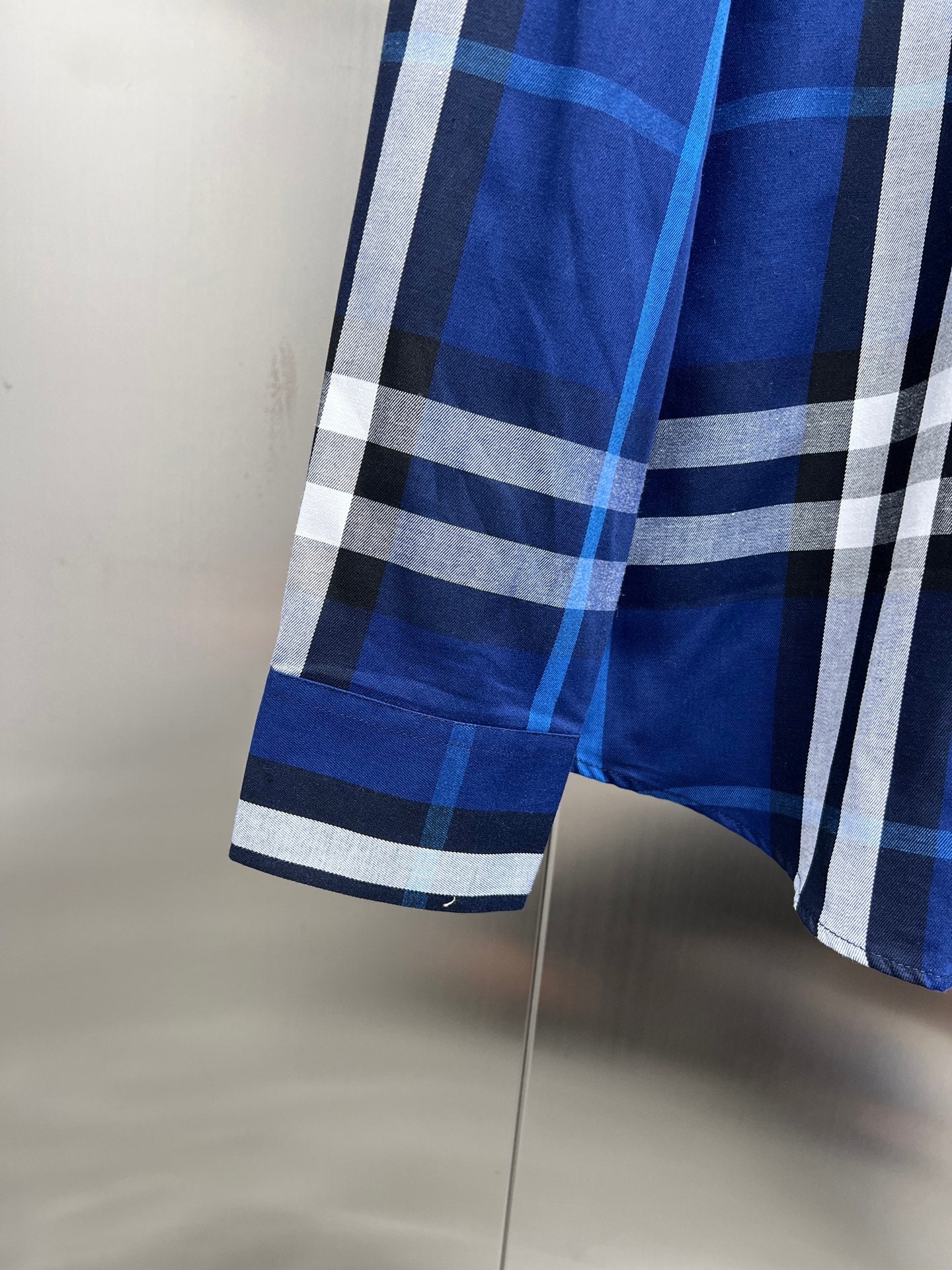 Blue and white plaid shirt sleeve and hem detail