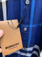 Blue plaid shirt front with buttons and hanging Burberry tag