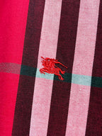 Embroidered red horse-and-rider logo on red plaid fabric
