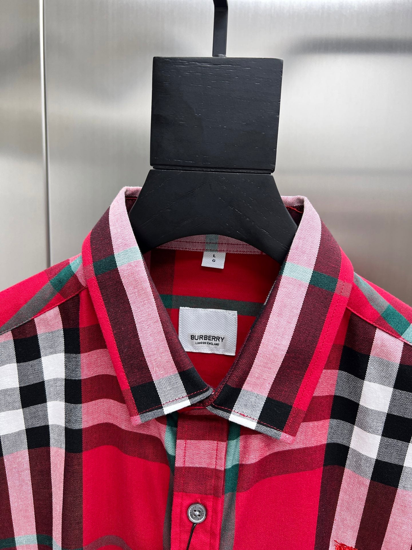 Red and black plaid button-up shirt collar with Burberry label inside neckline