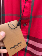 Burberry hang tag on red and black plaid button-up shirt front
