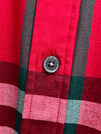 Round button on red and black plaid button-up shirt placket
