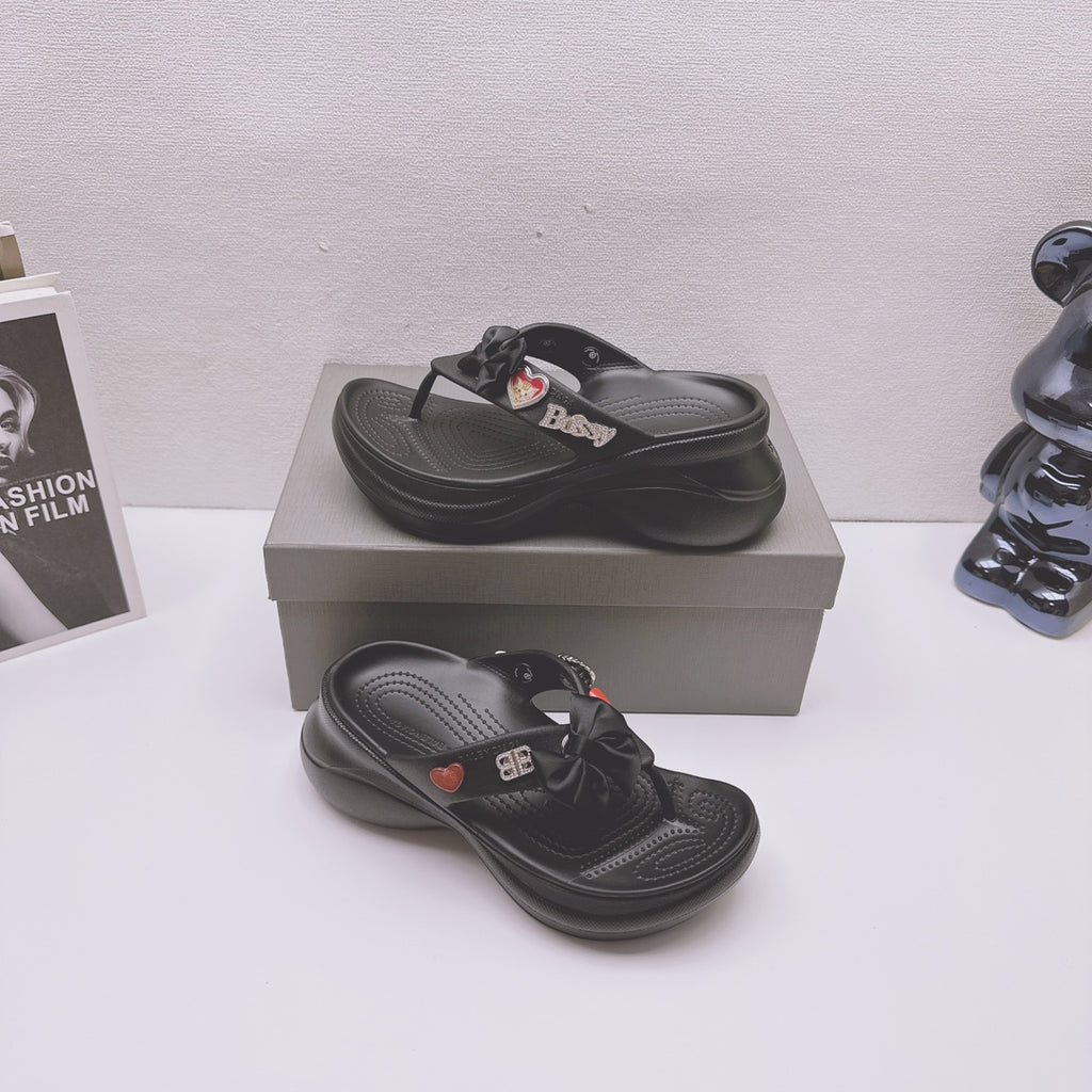 Black Balenciaga sandals shown with matching pair on a box, bow and heart accents