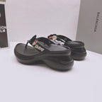 Black Balenciaga sandals with bow and heart patch decorations, angled side view