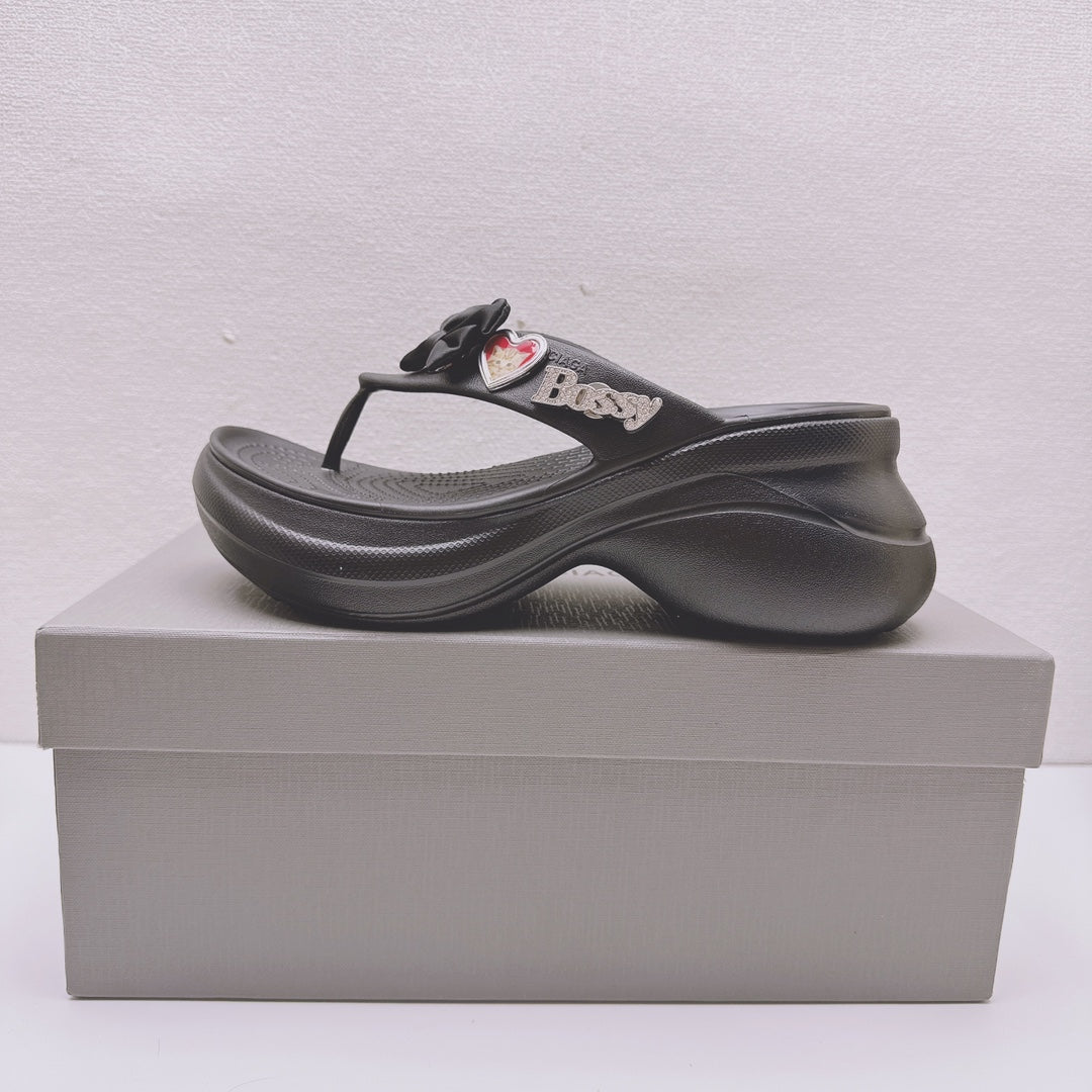 Black Balenciaga sandals with bow detail, heart patches, and thick contoured sole