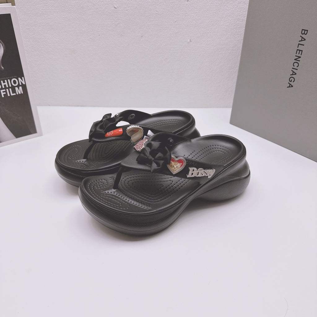 Pair of black Balenciaga sandals with bow straps, heart charms, and sculpted footbeds
