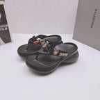 Pair of black Balenciaga sandals with bow straps, heart charms, and sculpted footbeds
