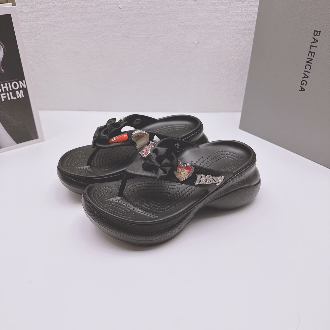 Pair of black Balenciaga sandals with bow straps, heart charms, and sculpted footbeds