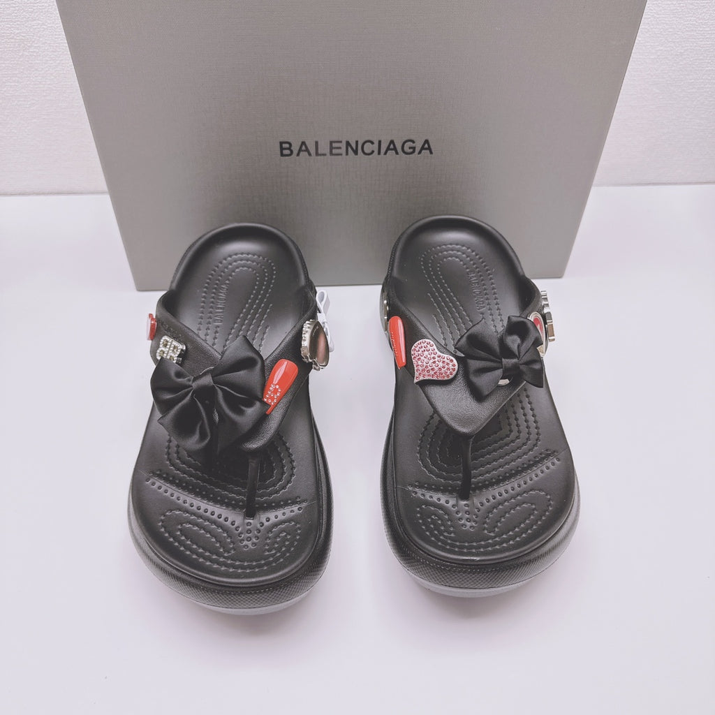 Black Balenciaga sandals, front view with bow straps, heart patch charms, and thick sole