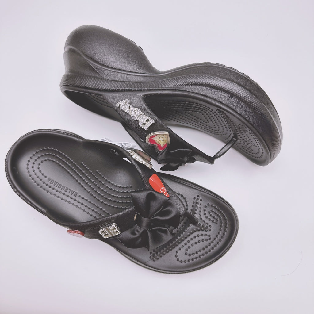 Black Balenciaga sandals with heart patch accents and bow strap on contoured sole