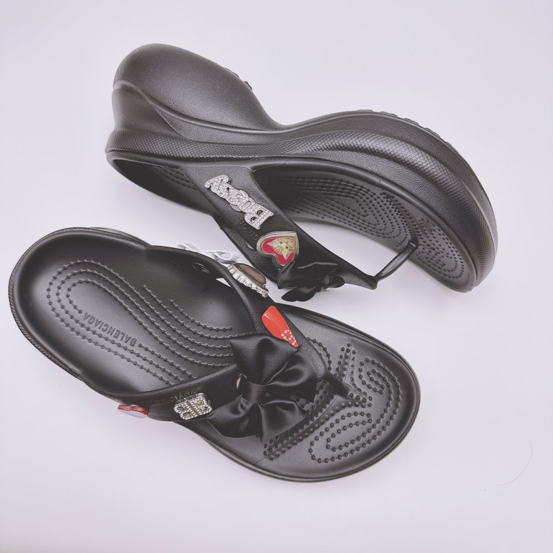 Black Balenciaga sandals with heart patch accents and bow strap on contoured sole