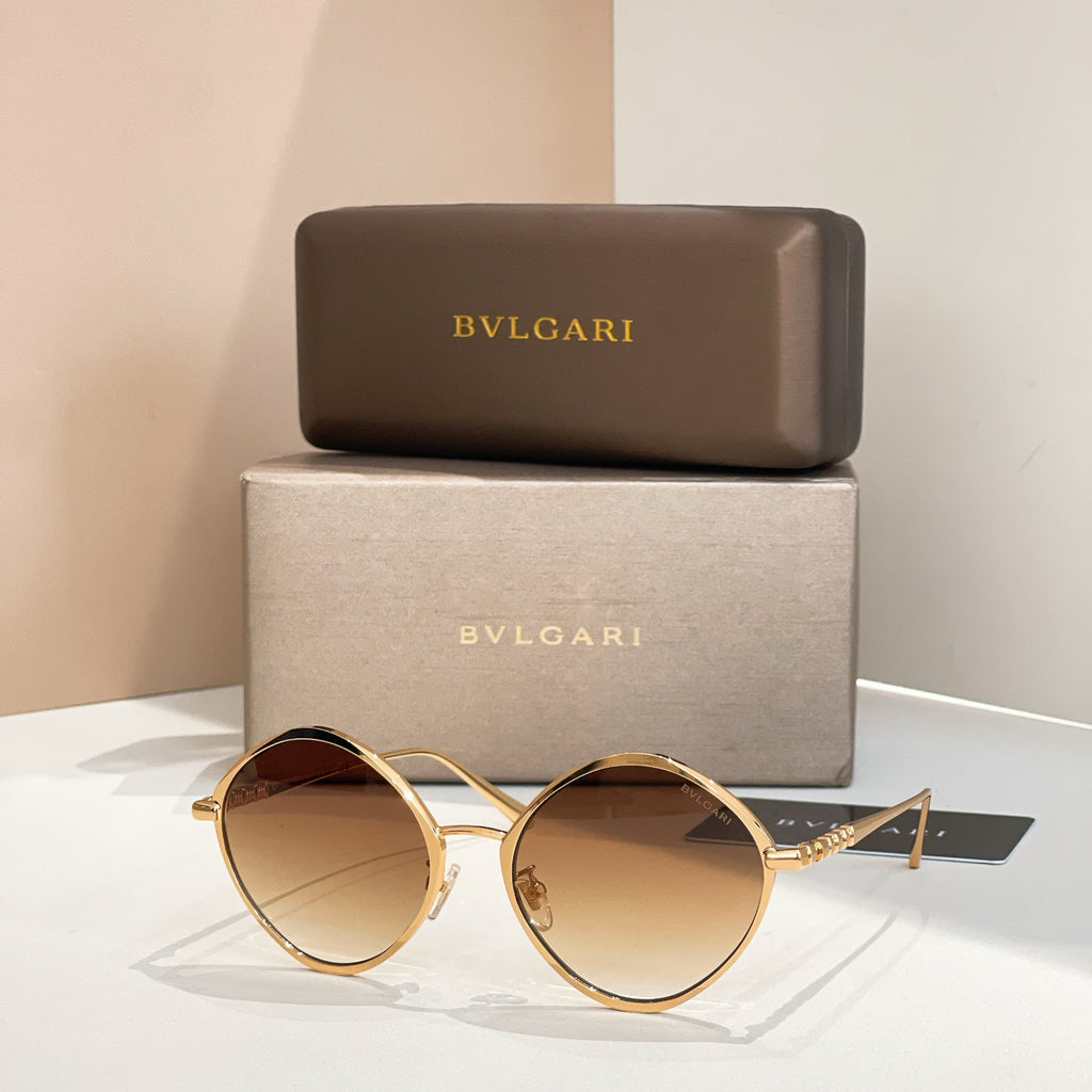 Gold round sunglasses with amber-tinted lenses and slim metal arms.