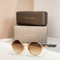 Gold round sunglasses with amber-tinted lenses and slim metal arms.