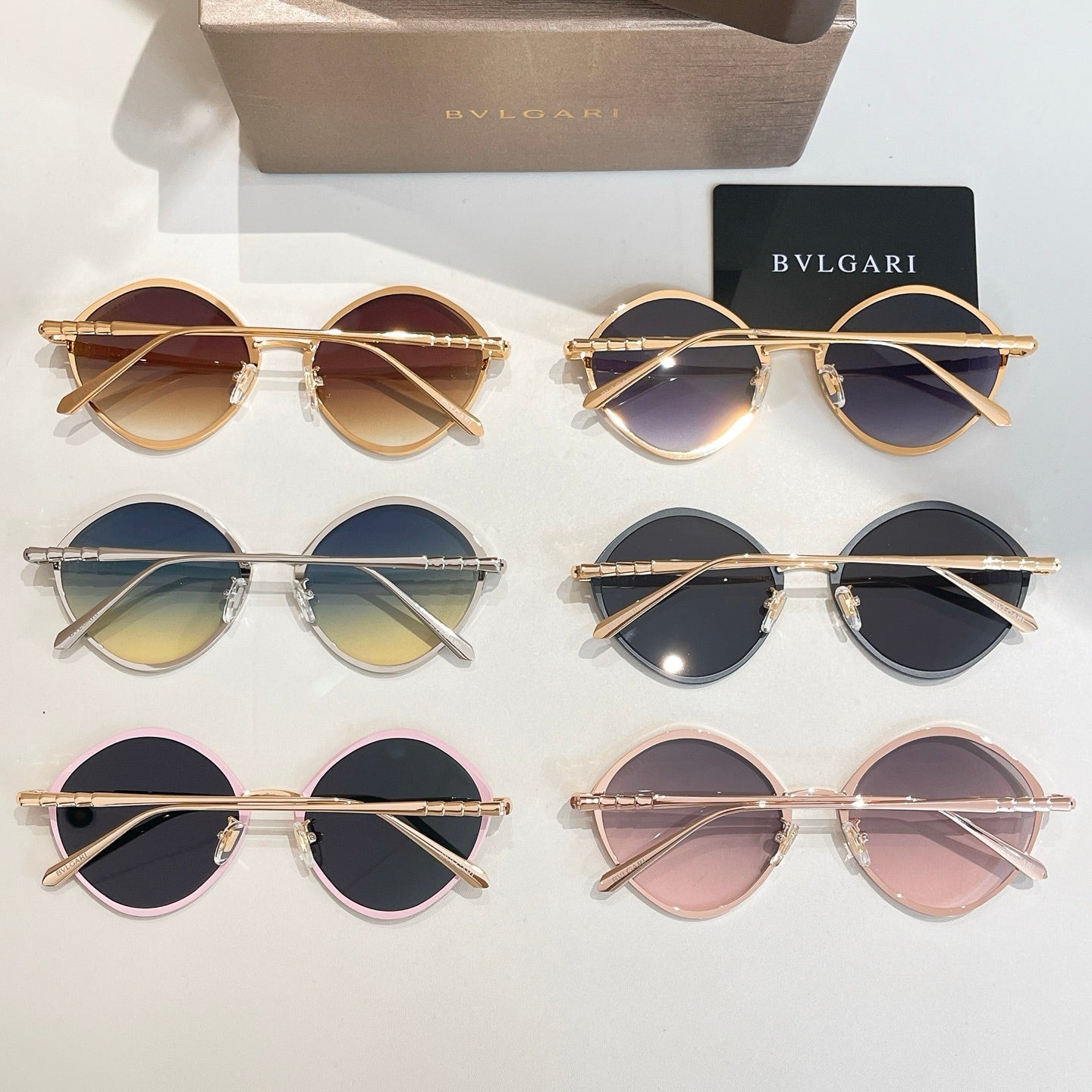 Assorted round sunglasses with gold and silver frames and tinted lenses.
