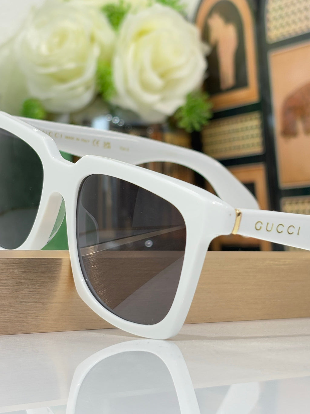 White Gucci square sunglasses close-up with dark tinted lenses