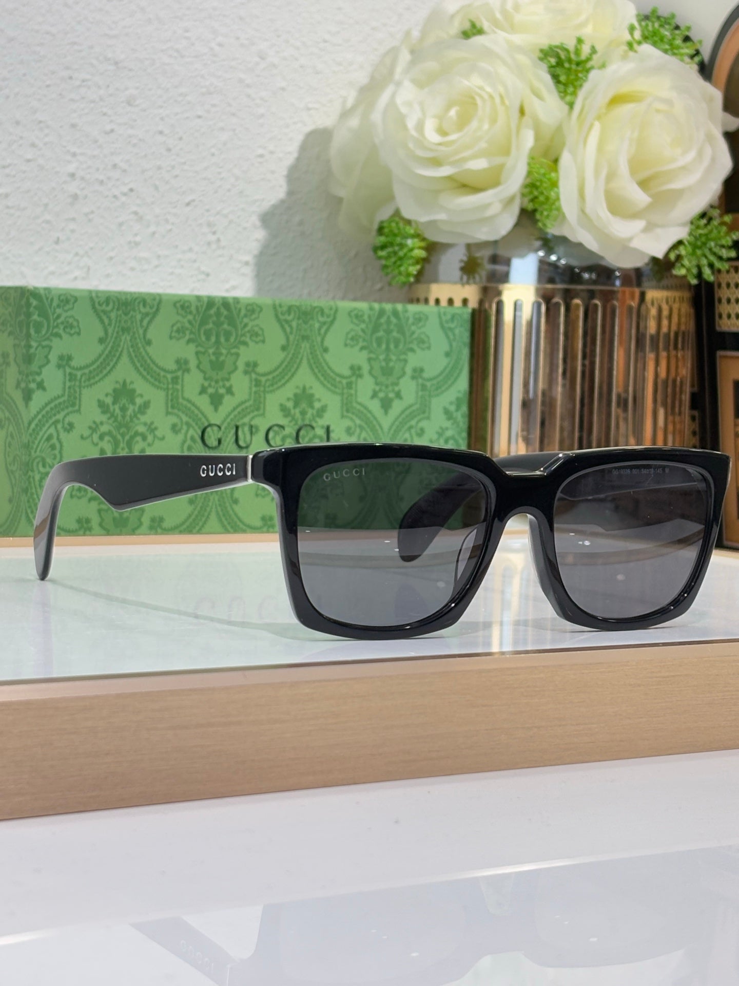 Black Gucci square sunglasses with dark tinted lenses and thick frames