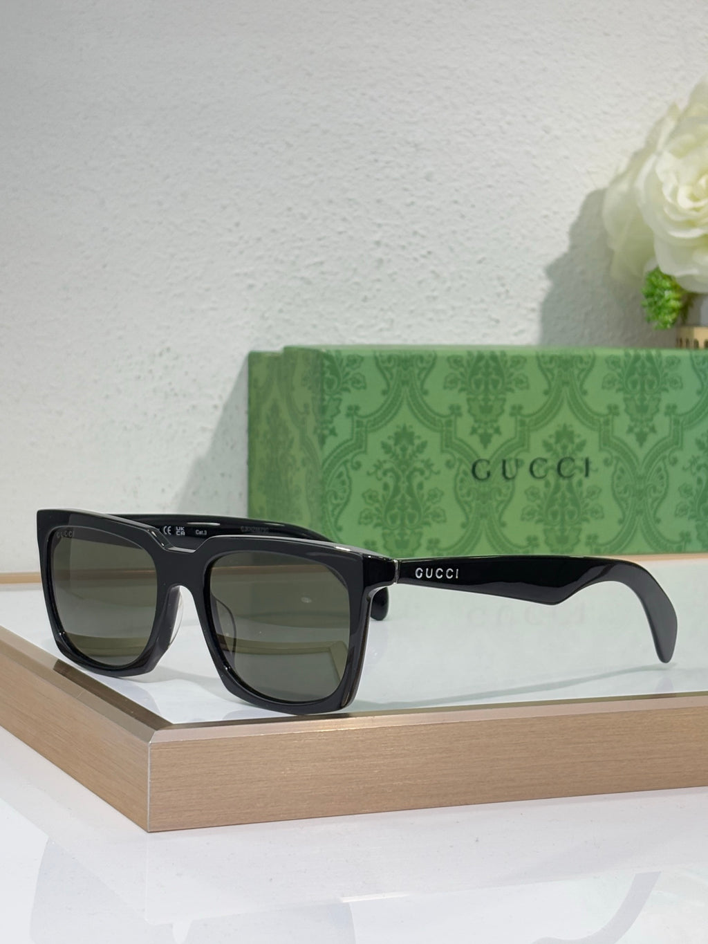 Black Gucci square sunglasses with dark lenses and thick glossy frames