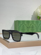 Black Gucci square sunglasses with dark lenses and thick glossy frames