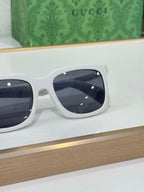 White Gucci square sunglasses close-up with dark tinted lenses