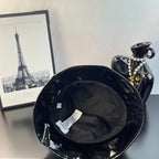 Glossy black bucket hat interior with adjustable strap and label
