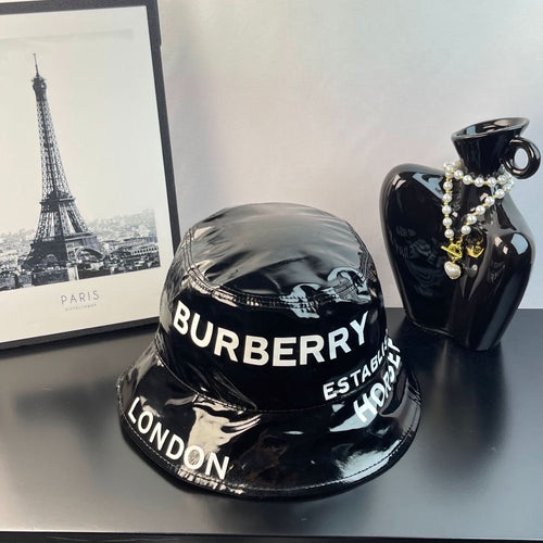 Glossy black bucket hat with Burberry lettering and London on the brim