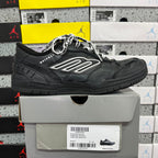 Black low-top sneaker with silver logo patch and lace-up upper on box