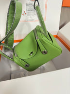 Green leather Hermes mini handbag with top handle and shoulder strap, silver hardware