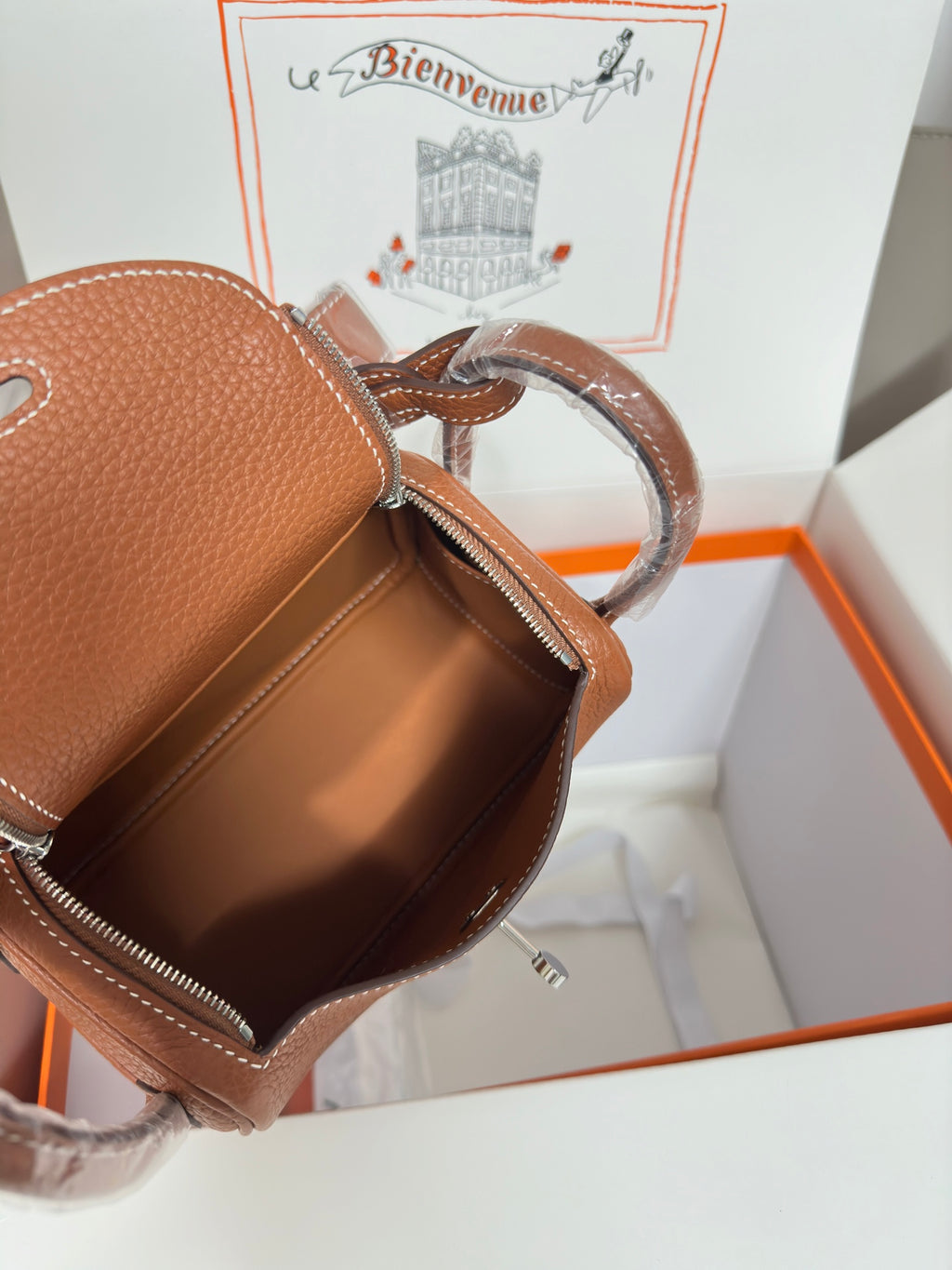 Hermes mini leather handbag side view in tan pebbled leather with zipper and leather strap