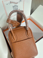 Hermes mini leather handbag in tan with wide top handles, front flap, and silver clasp