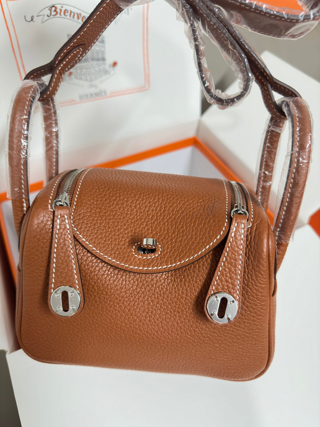 Hermes mini leather handbag in tan with front flap turn-lock and silver ring pulls