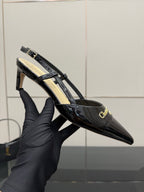 Black patent slingback heel with gold logo buckle and strap detail