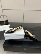 Black pointed-toe slingback heels with gold logo hardware and stiletto heel
