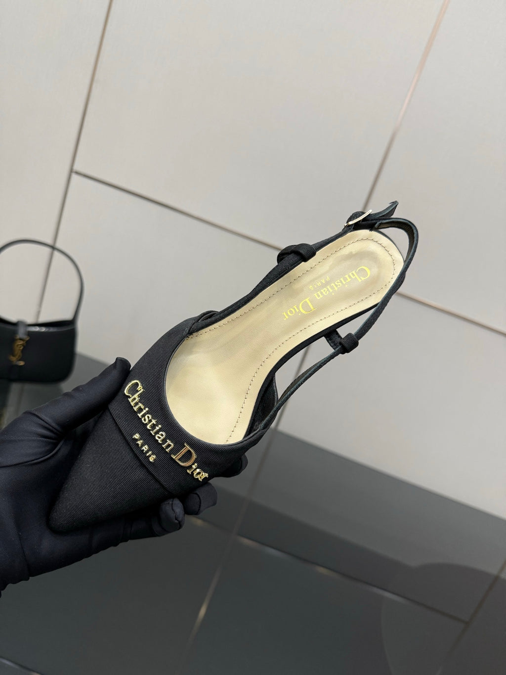 Black slingback heel showing cream insole and gold logo