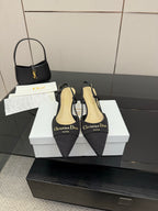 Black pointed-toe slingback high heels with thin straps and gold logo detail