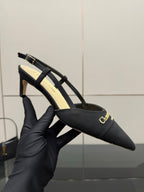 Black pointed slingback heels with gold buckle strap detail