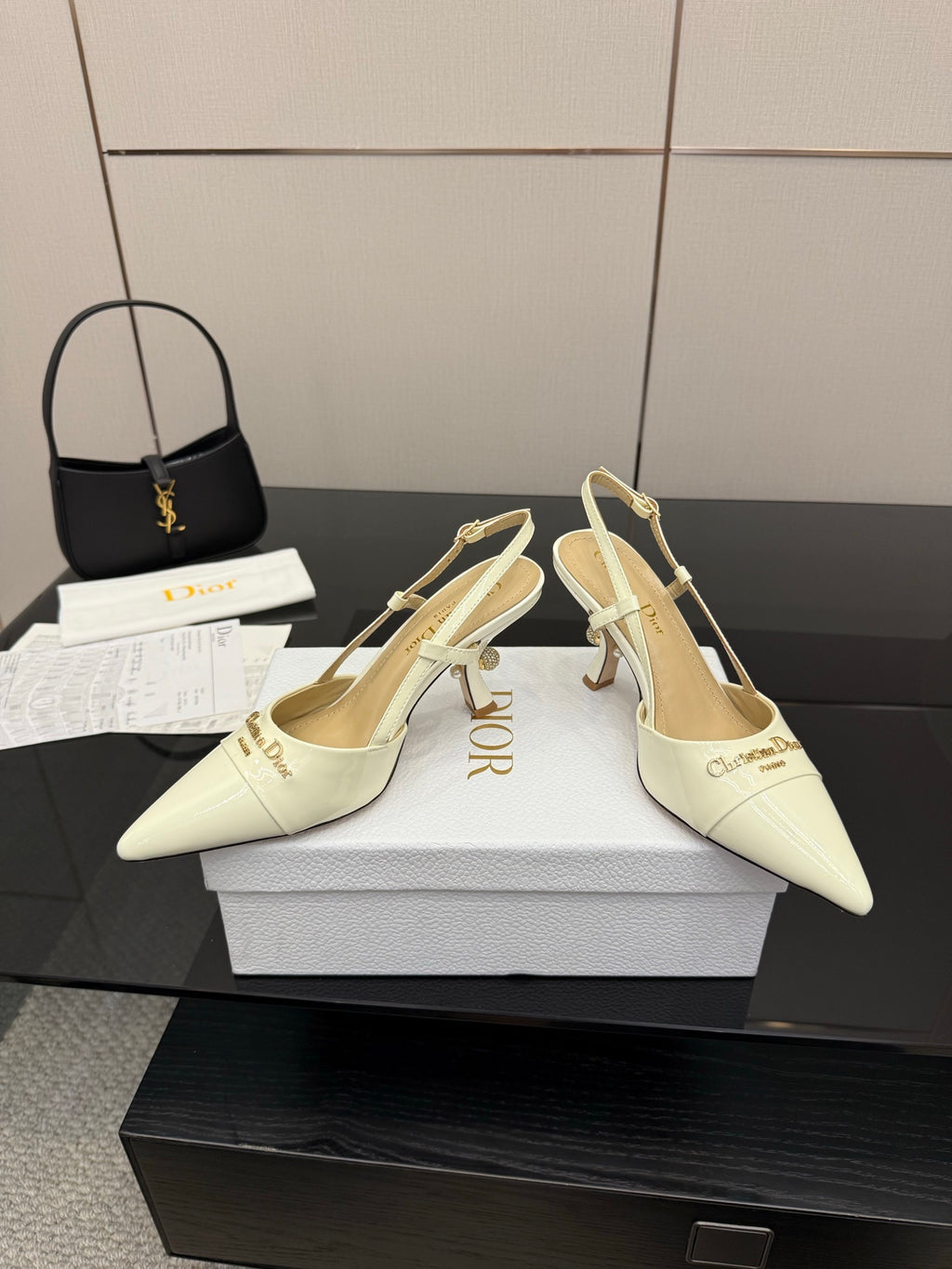 Ivory slingback pumps on white boxes, pointed toe, gold-tone heel and ankle straps