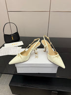 Ivory slingback pumps on white boxes, pointed toe, gold-tone heel and ankle straps
