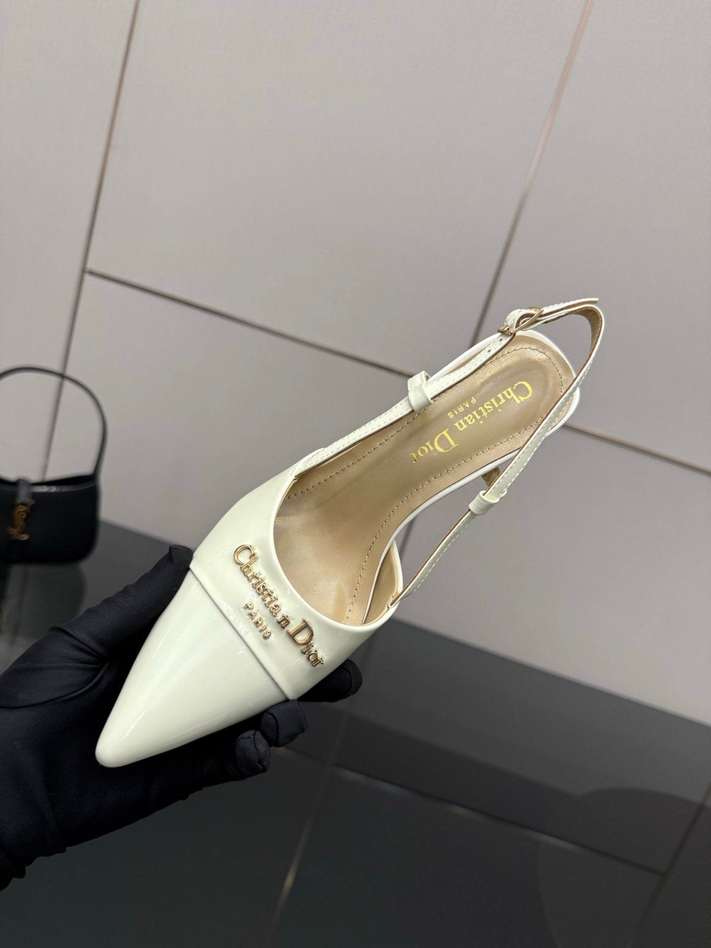 Ivory pointed-toe slingback pump angled view, gold-tone trim and ankle strap