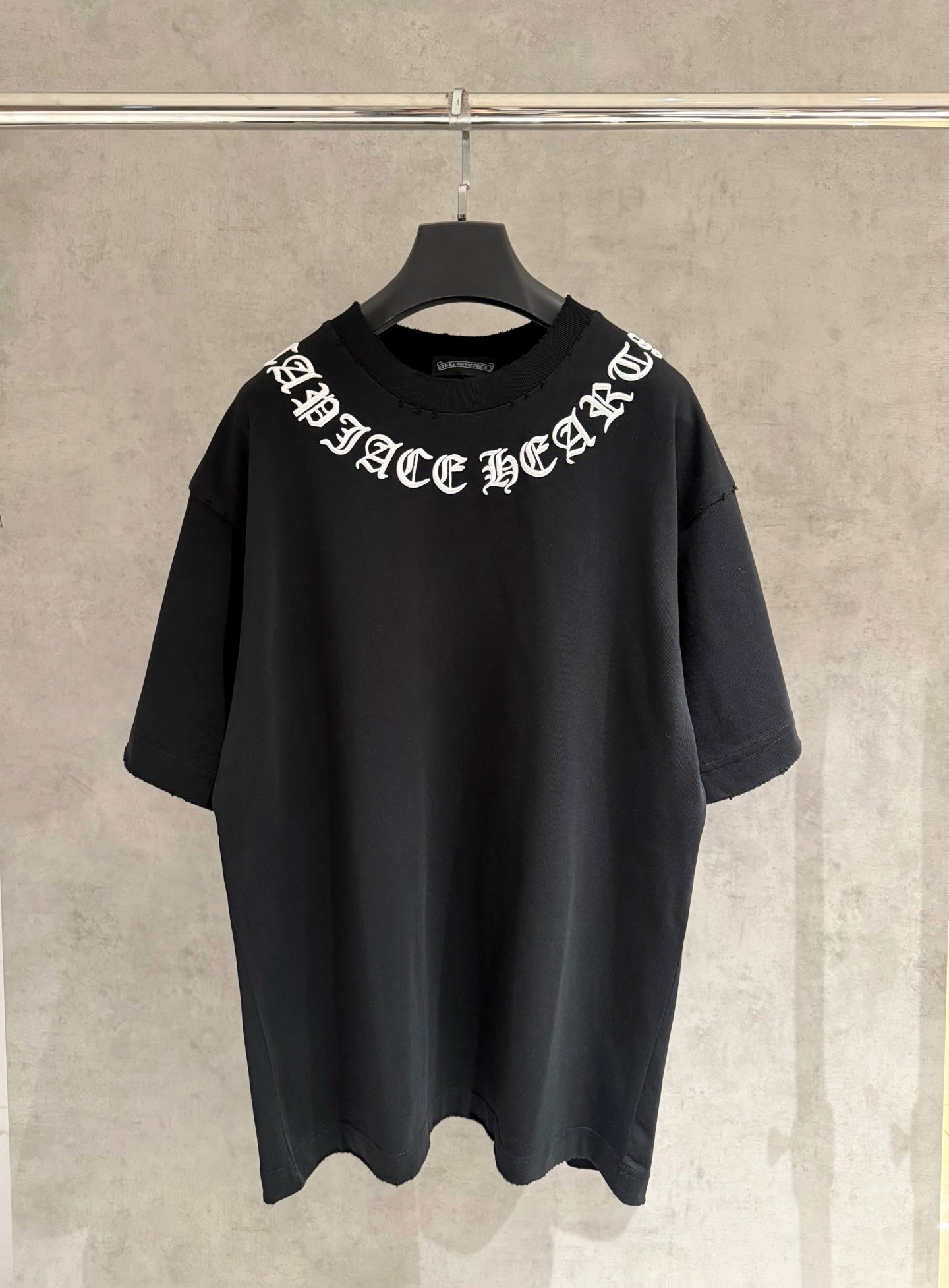 Black short-sleeve T-shirt with white logo text across chest