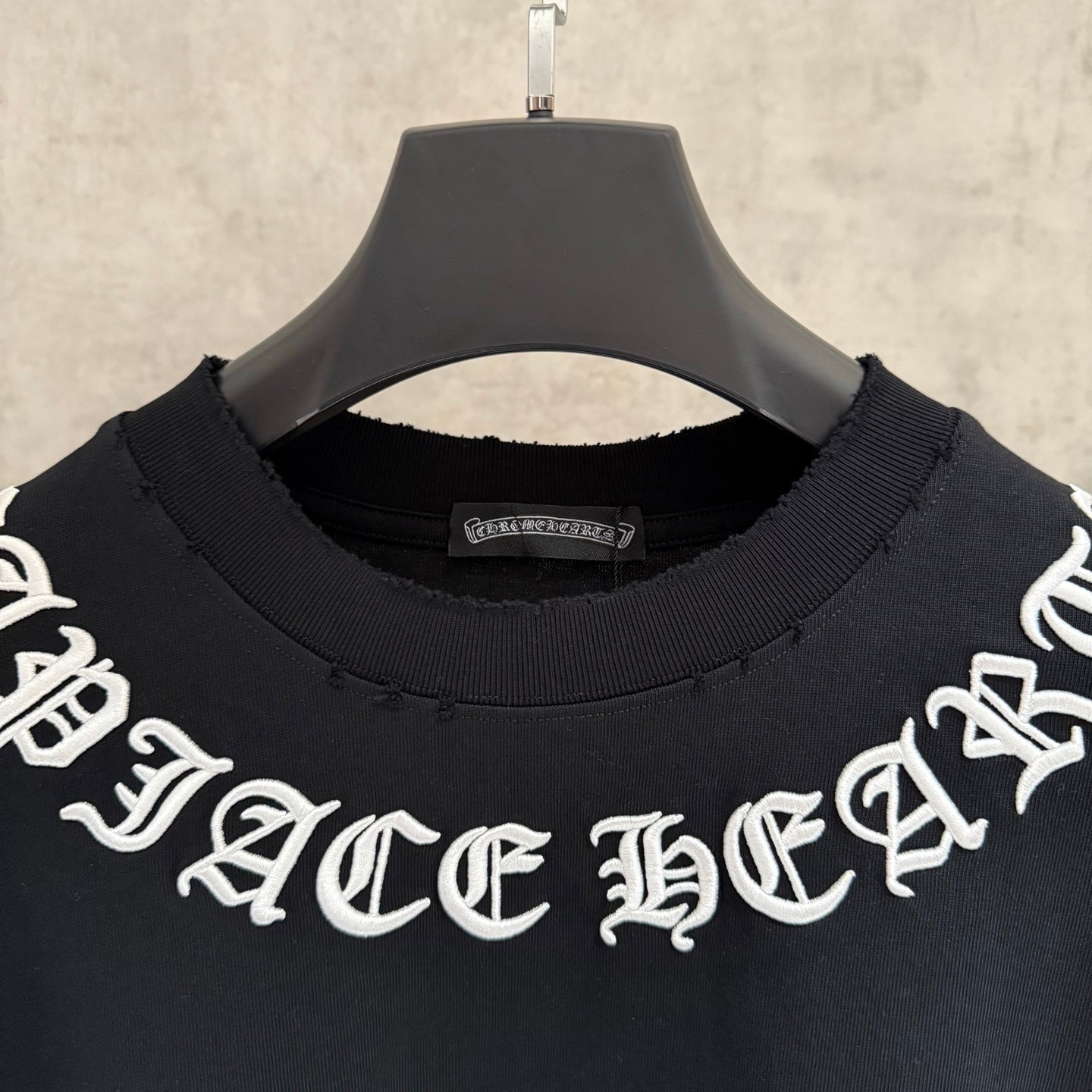 Black crew-neck T-shirt with white logo lettering on chest